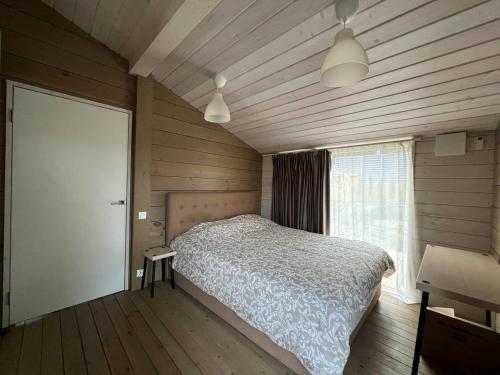 a bedroom with a bed in a room with wooden walls at La Dacha Montanya in Seva