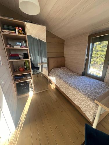 a small bedroom with a bed and a window at La Dacha Montanya in Seva