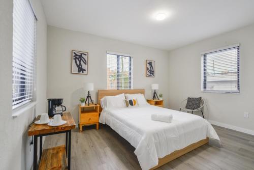 a white bedroom with a bed and a table at Prime Location Apartment at Calle Ocho in Miami