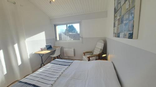- une chambre avec un lit dans une chambre avec un bureau dans l'établissement LES MUGUETS - Maison 4 chambres à 600m de la plage, à Saint-Hilaire-de-Riez