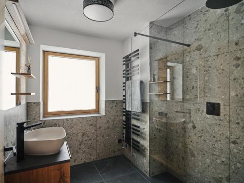 a bathroom with a sink and a glass shower at Lodge am Wetterstein in Ehrwald