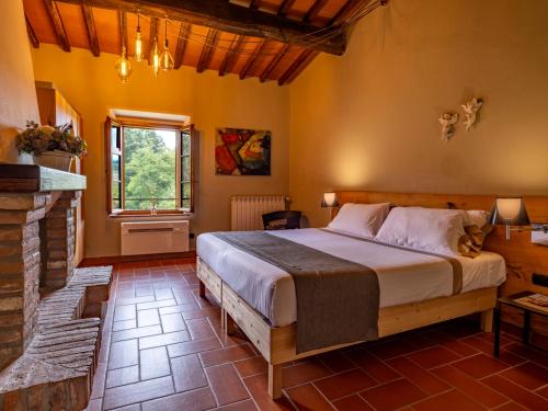 a bedroom with a large bed and a fireplace at Villa Poggio alla Staffa in Poderi Foci