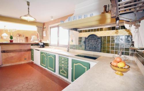 - une cuisine avec des armoires vertes et un bol de fruits sur le comptoir dans l'établissement 3 Bedroom Gorgeous Home In Venasque, à Venasque