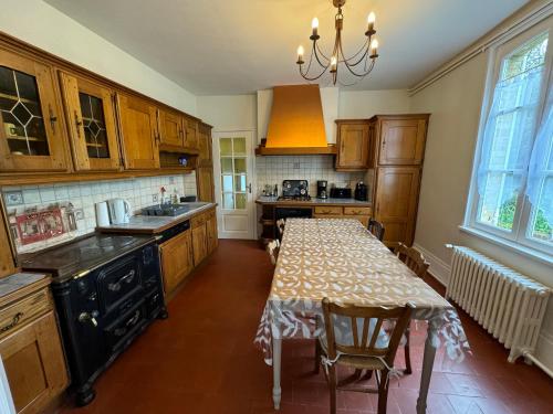 une cuisine avec une table et un évier et une table et des chaises dans l'établissement Maison de ville avec ruisseau, Wifi, Tv, Jardin, à Saint-Désir