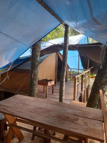 a tent with a wooden table and a bench at Rustic Campsite Kalutara South in Kalutara