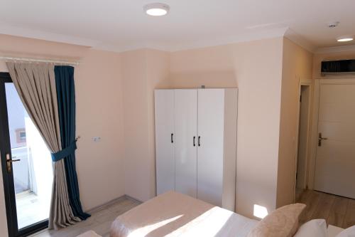 a bedroom with a bed and a cabinet and a window at Şahin Tepesi Suite Otel in Trabzon