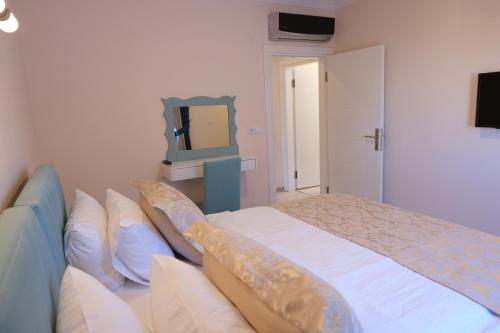 a bedroom with a large bed and a television at Şahin Tepesi Suite Otel in Trabzon