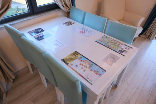 a white table with blue chairs and cards on it at Şahin Tepesi Suite Otel in Trabzon