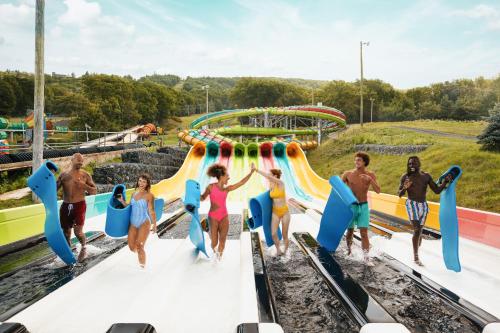 a group of people jumping on a water slide at an amusement park at Camelback Resort in Tannersville