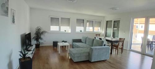 a living room with a couch and a table at Neubau Appartement mit Terasse, privater Eingang,Parkplatz,Küche in Fürth