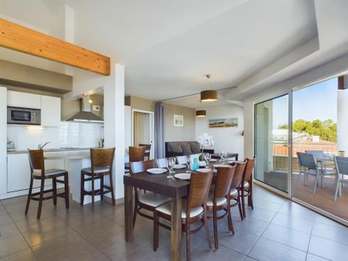 une salle à manger et une cuisine avec une table et des chaises dans l'établissement Bord de plage, appartement pour 12, vue mer, à La Tranche-sur-Mer
