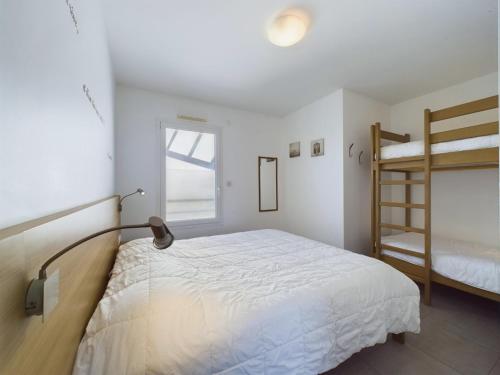 une chambre avec un lit et un lit superposé dans l'établissement Bord de plage, appartement pour 12, vue mer, à La Tranche-sur-Mer