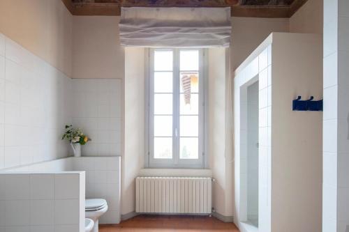 a bathroom with a toilet and a window at Villa Berla in Azzate