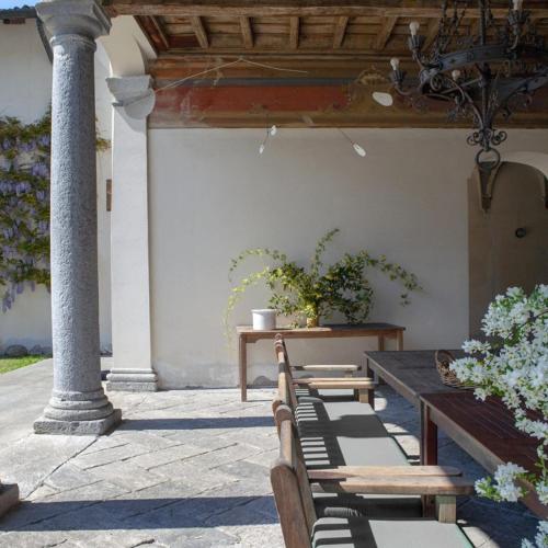a patio with benches and a table with plants at Villa Berla in Azzate