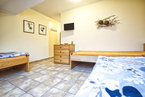 a bedroom with two beds and a dresser at Penzion Vinařství Červinka in Horní Věstonice