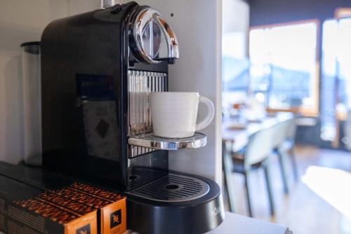 a coffee maker with a cup on top of it at Hunter Lodge by Gryon Confort in Gryon