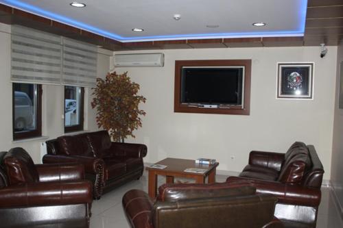 a living room with leather furniture and a flat screen tv at Lifos Hotel in Kayseri