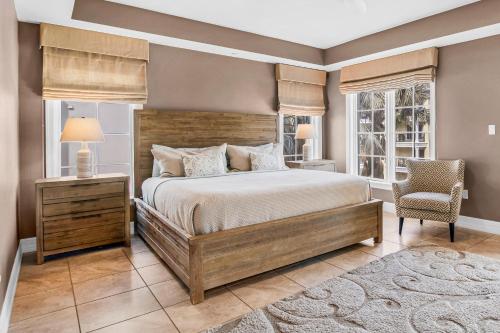 een slaapkamer met een bed, een stoel en ramen bij An Upscale Villa in the heart of Siesta Key on Beach Road in Sarasota