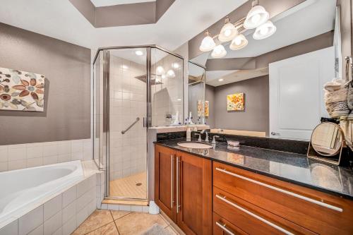 een badkamer met een bad, een wastafel en een douche bij An Upscale Villa in the heart of Siesta Key on Beach Road in Sarasota