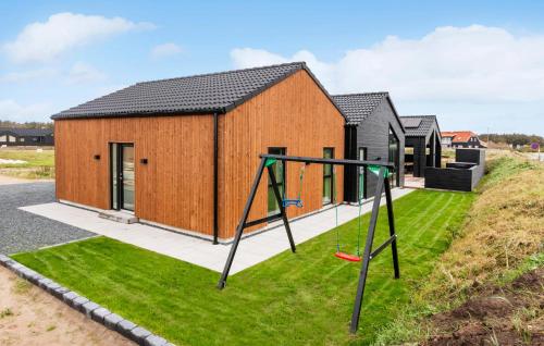 a house with a playground in front of it at Awesome Home In Løkken With Sauna in Løkken