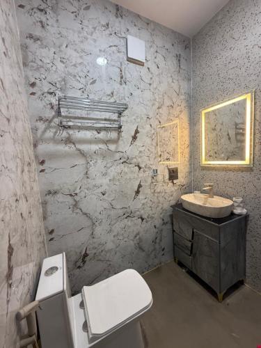 Un baño con un inodoro blanco y un lavabo. en Dhaulidhar Farms, en Greater Noida