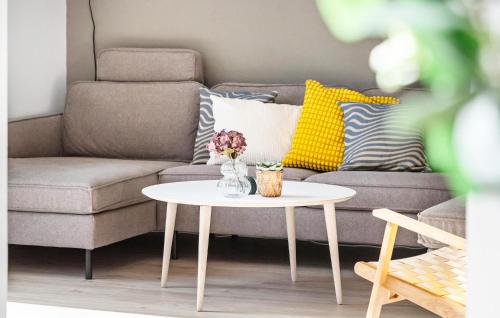 a living room with a couch and a table at Awesome Home In Løkken With Sauna in Løkken