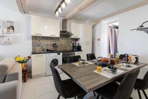 une cuisine et une salle à manger avec une table et des chaises dans l'établissement Charmant appartement, emplacement exceptionnel, à Villeneuve-lès-Béziers
