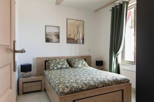 une chambre avec un lit et deux tableaux au mur dans l'établissement Charmant appartement, emplacement exceptionnel, à Villeneuve-lès-Béziers