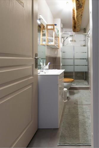 une salle de bain blanche avec un lavabo et des toilettes dans l'établissement Charmant appartement, emplacement exceptionnel, à Villeneuve-lès-Béziers