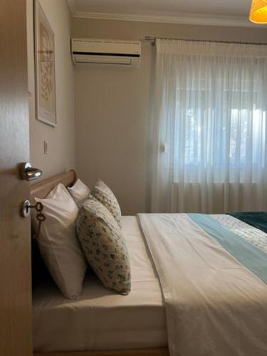 a bedroom with a bed with pillows and a window at ELIA Guesthouse in Komotini