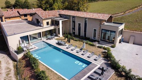 une vue aérienne d'une maison avec piscine dans l'établissement Villa Molinant, évasion en Pierres Dorées, à Bagnols