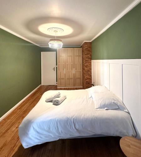 une chambre avec un grand lit avec un mur végétal dans l'établissement Le Square, au Havre