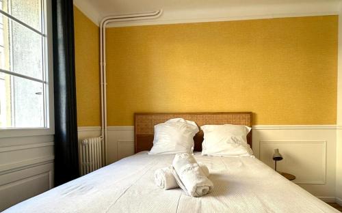 a bedroom with a bed with two pillows on it at Le Square in Le Havre