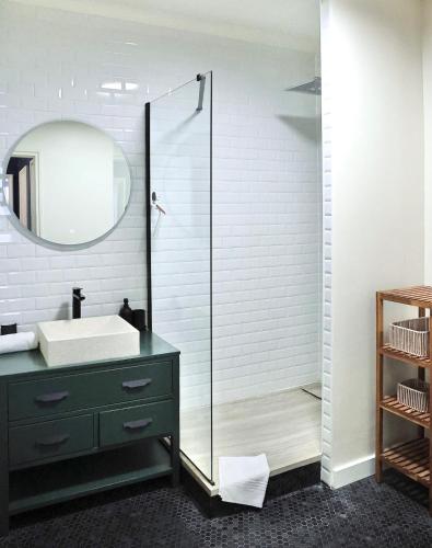 une salle de bain avec un lavabo et une douche en verre dans l'établissement Le Square, au Havre