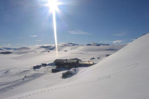 a building in the middle of a snow covered field at Bergsjøstølen Fjellstue in Bergsjostolen