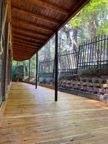 a porch with a wooden deck with flowers on it at Hotel Gloria KS in Pristina