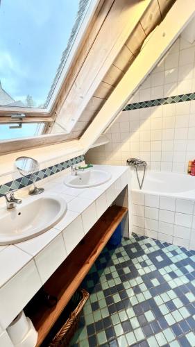 une salle de bain avec deux lavabos et une baignoire dans l'établissement Chaumière bord de mer, à Keranquernat