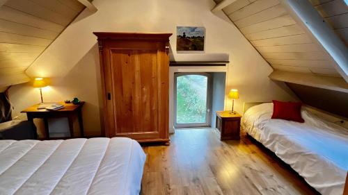 une chambre mansardée avec un lit et une fenêtre dans l'établissement Chaumière bord de mer, à Keranquernat