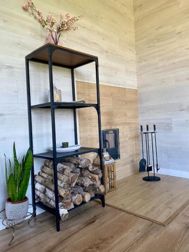 a black shelf with a pile of fire wood at Sauna for celebration and leisure in Grygaytse