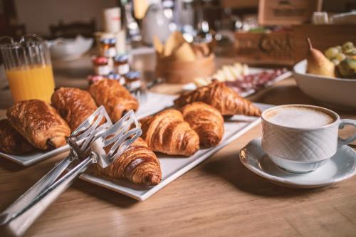 a table with plates of pastries and a cup of coffee at Albergo Giovanni Da Verrazzano in Greve in Chianti