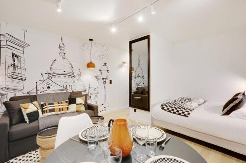une chambre avec un lit, une table et un canapé dans l'établissement Au coeur du sacré coeur, à Paris