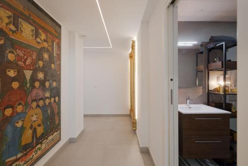 a hallway with a painting on the wall next to a bathroom at BlueSunset Penthouse in Manilva