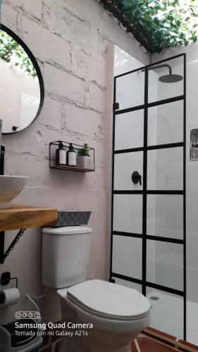 a bathroom with a toilet and a sink and a mirror at CASA HOTEL LAS HORTENSIAS in Jardin