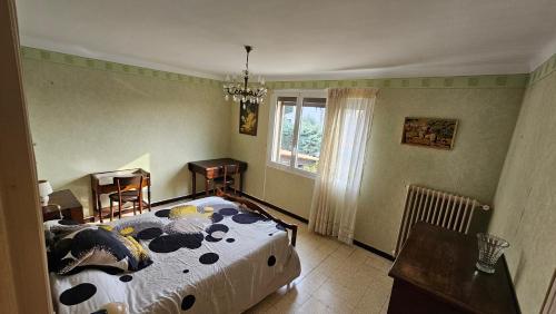 a bedroom with a bed and a table and a window at Maison avec 3 chambres et jardin in Saint-Estève