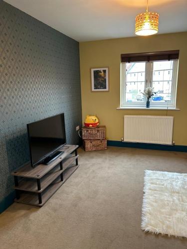 a living room with a flat screen tv and a window at Wonderful two bedroom house in Bicester in Chesterton