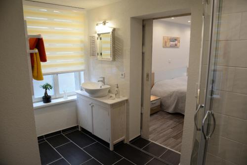 een badkamer met een wastafel, een douche en een bed bij Wohnen am Kaiserturm in Quedlinburg