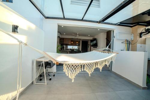 a hammock in a room with a kitchen at Espectacular Casa de Ensueño "Jacuzzi Privado" en Ricaurte - Peñalisa in Ricaurte