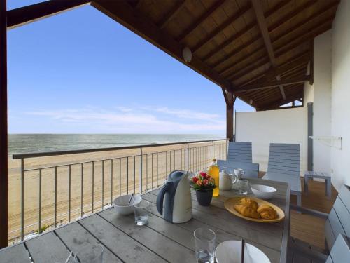 une table avec de la nourriture et une vue sur la plage dans l'établissement Sur la plage, appartement avec terrasse et vue mer, à La Tranche-sur-Mer
