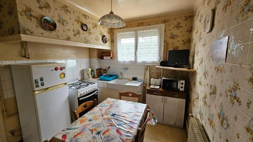 une petite cuisine avec un réfrigérateur et une table dans l'établissement Maison avec 3 chambres et jardin, à Saint-Estève