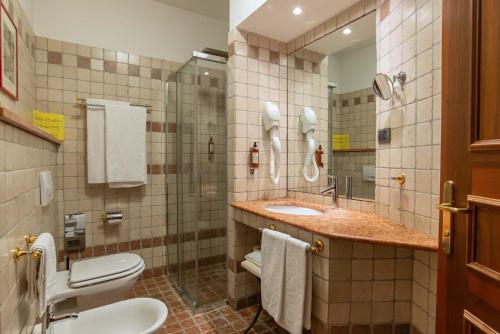 a bathroom with a sink and a toilet and a mirror at Relais Du Foyer in Châtillon